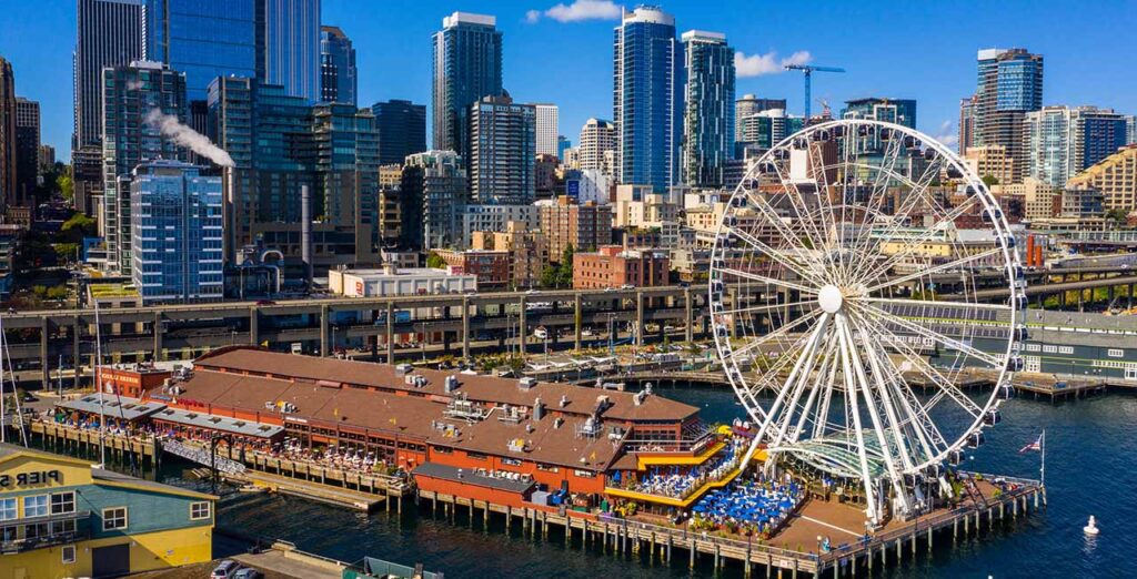 An image of a ferris wheel with a modern city behind.