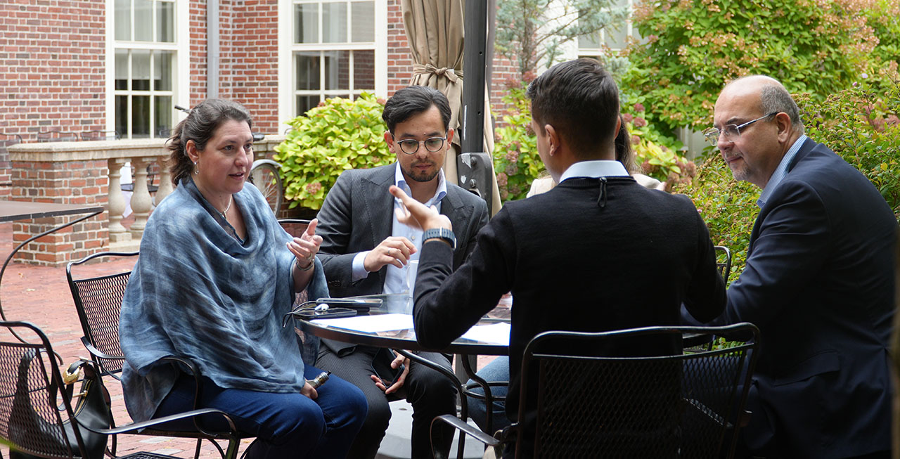 active discussion in a green garden in front of a brick building