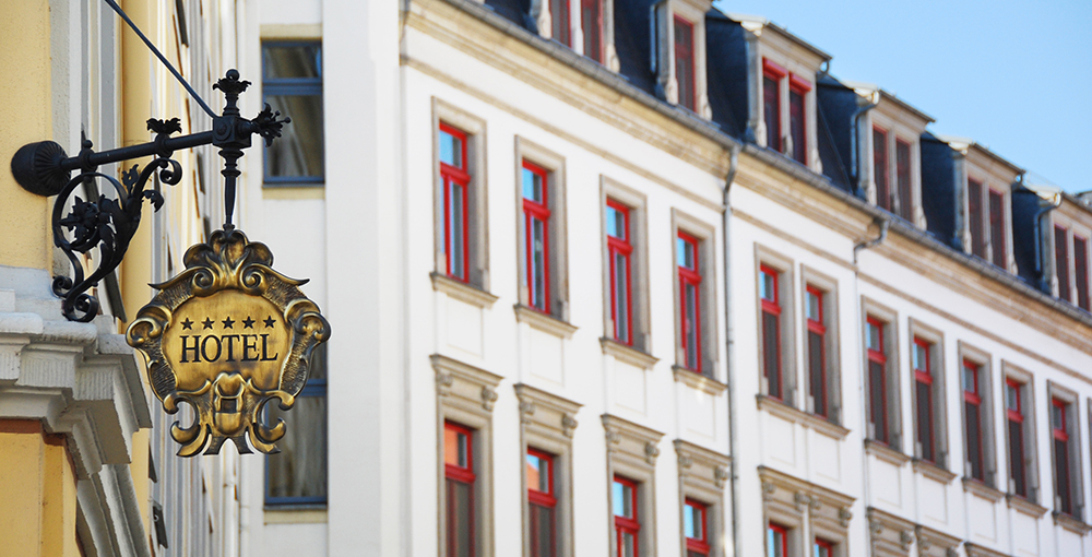 an image of a hotel facade with a hotel sign in the foreground