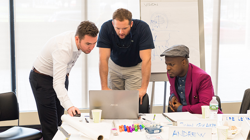 participants in a classroom assessing a hotel design on a laptop